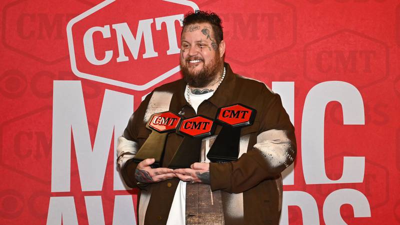 Jelly Roll holding three CMT awards