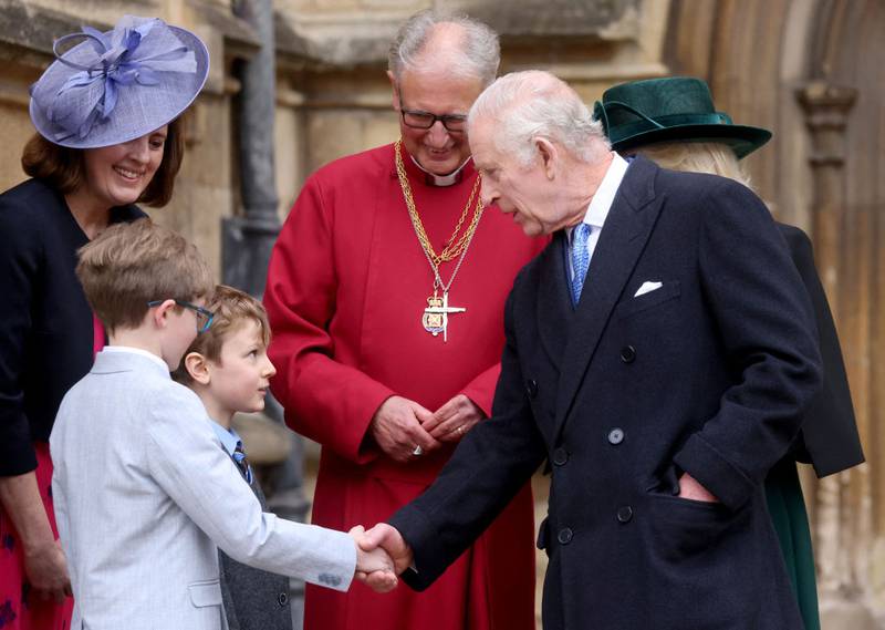 WINDSOR, ENGLAND - MARCH 31: King Charles III and Queen Camilla shakes hands with some boys as they leave after attending the Easter Mattins Service at Windsor Castle on March 31, 2024 in Windsor, England. (Photo by Hollie Adams - WPA Pool/Getty Images)